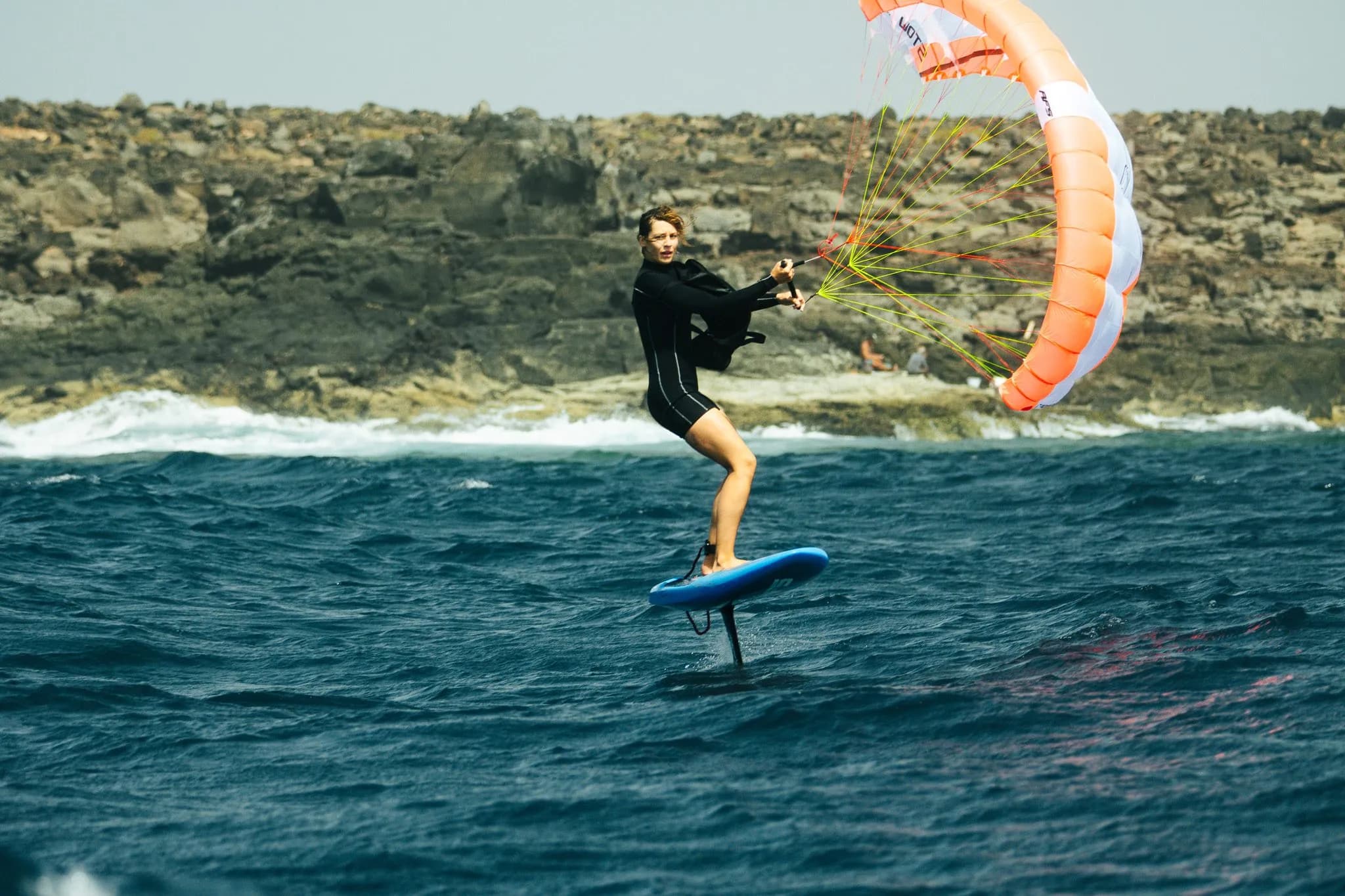 Rider de parawing foil frente a un acantilado