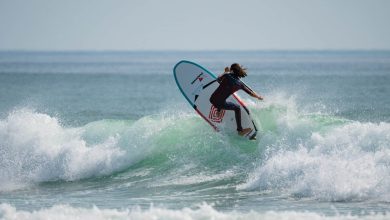 Une personne chevauchant une planche de surf sur une vague